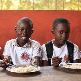 Schoolchildren enjoying school meals supported by WFP. Photo: WFP/Renata Lobo
